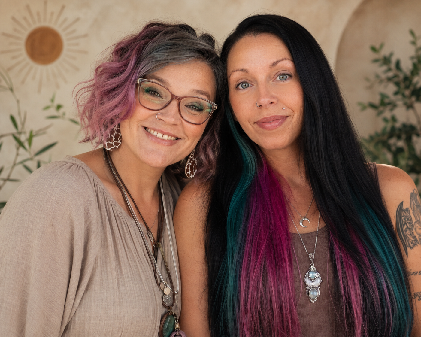 Courtnie and Bunni smiling side by side in front of a warm sun-motif wall